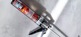 Fix All High Tack włożony w pistolet do kleju leży na betonowym podłożu