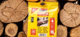 Opakowanie ściereczek Soudal Swipex powieszone na tle sterty drewna