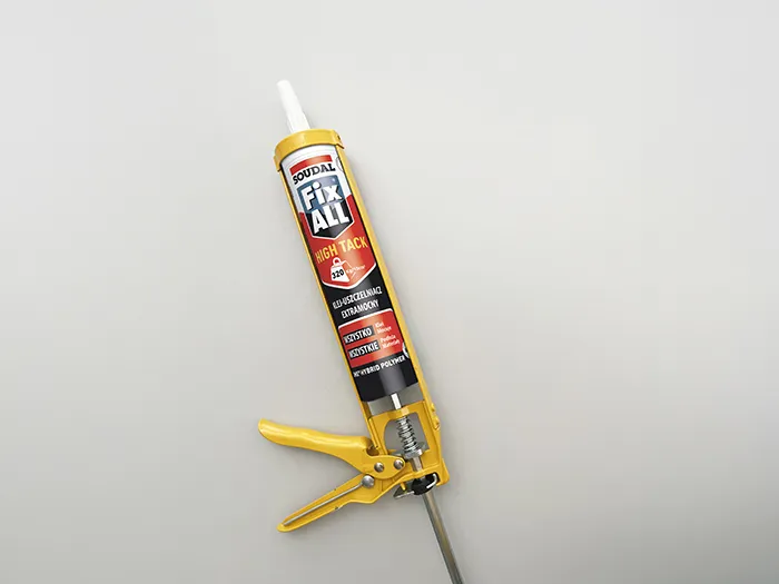 Soudal Fix All High Tack w żółtym pistolecie aplikacyjnym — extramocny klej montażowy SMX do wszystkich materiałów, gotowy do użycia.