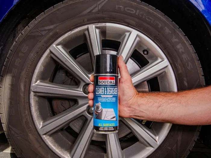 Zdjęcie produktu – aerozol czyszczący Cleaner & Degreaser firmy Soudal na tle koła samochodu