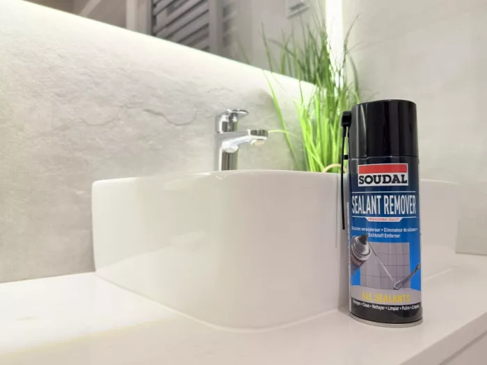 Widok na Sealant Remover stojący na blacie w łazience obok białej umywalki