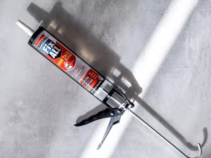 Klej montażowy Fix All High Tack Clear firmy Soudal leży na szarej powierzchni